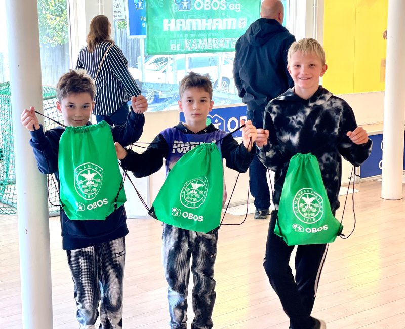 Fornøyde gutter med goodiebags fylt med HamKam-artikler og kampbilletter.